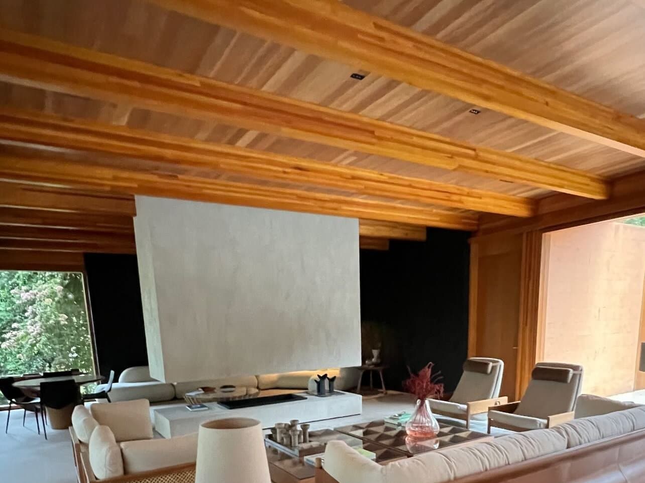 Sala de residência de alto padrão sob vigas de madeira engenheirada de longos vãos, obra da Arte Construir na Região Serrana