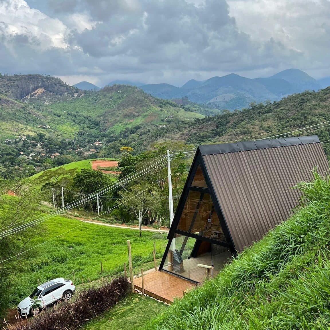 Chalé A-frame entregue pela Arte Chalés em Itaipava, em encosta verde com vista das montanhas