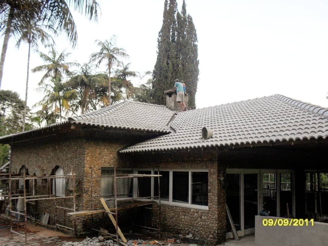 Reforma de telhado em casa de pedra, com andaimes