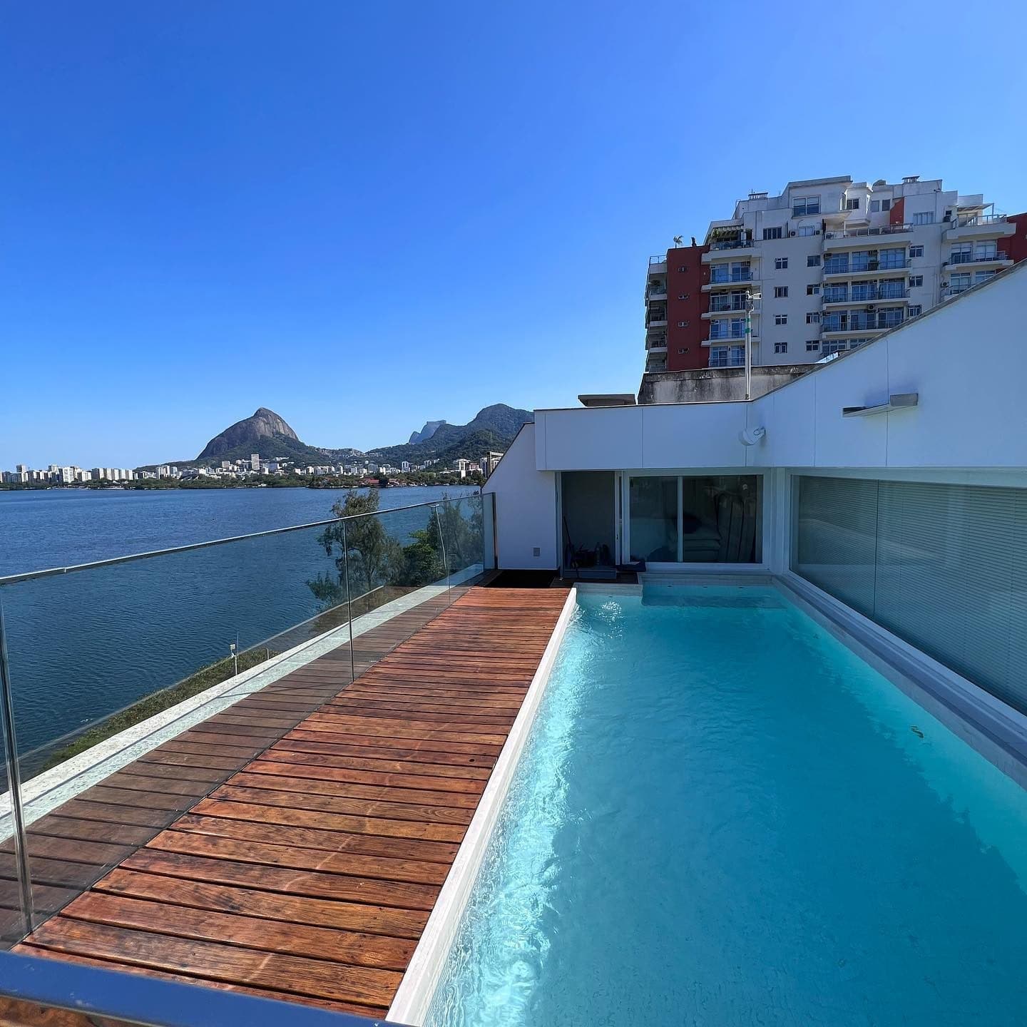 Piscina de cobertura com deck de madeira de demolição e vidro