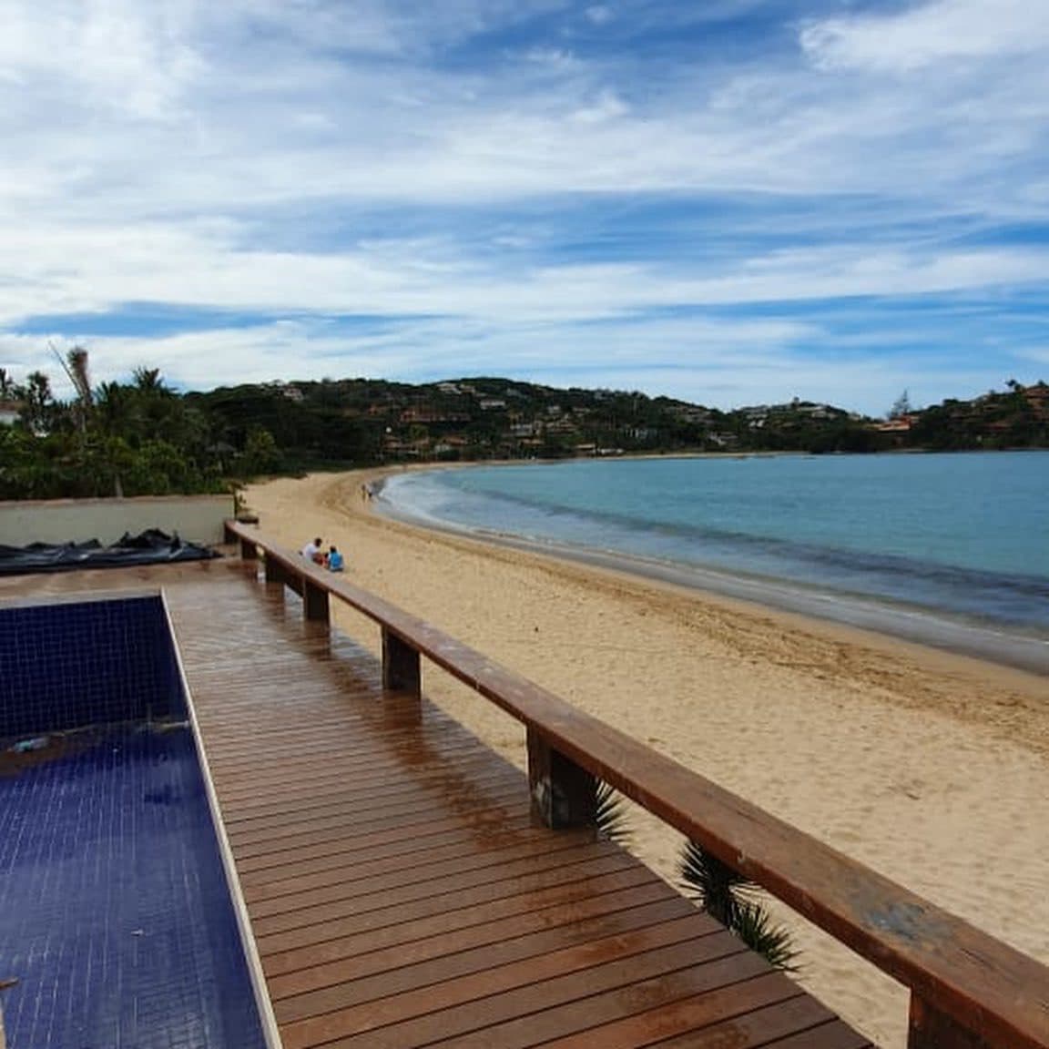 Deck com banco corrido junto à piscina e à praia