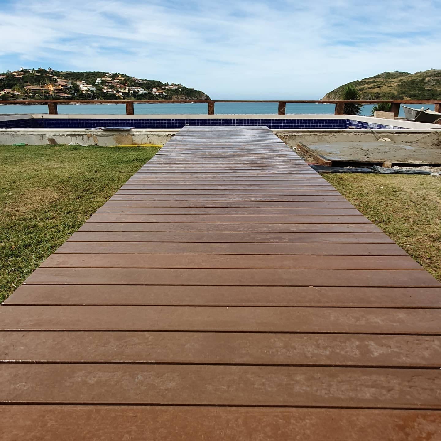 Passarela de deck em madeira plástica sobre o gramado até o mar