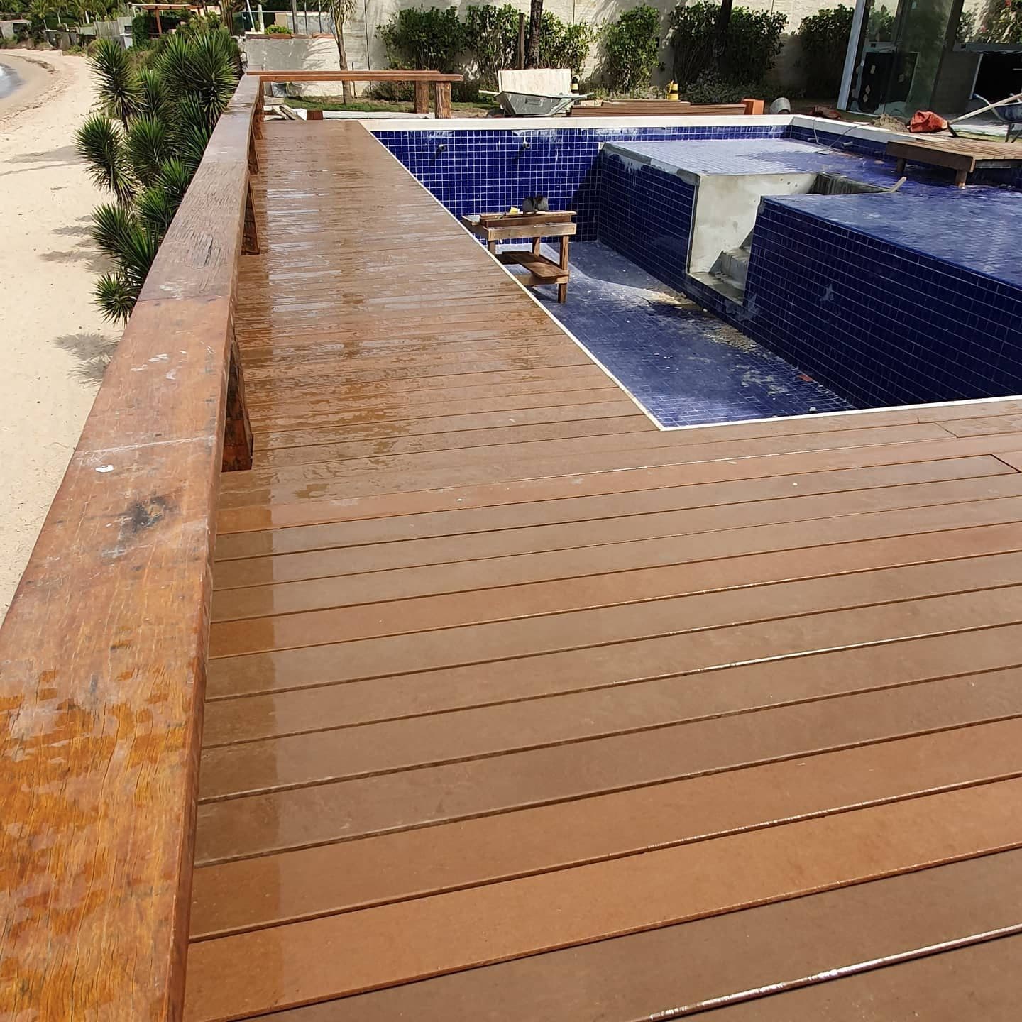 Deck em L ao longo da piscina, com vista da praia