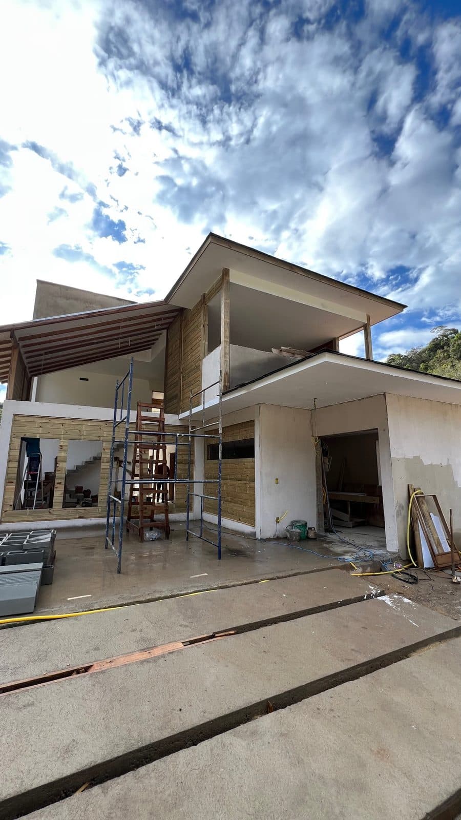 Sobrado em obra com cobertura de madeira e andaimes