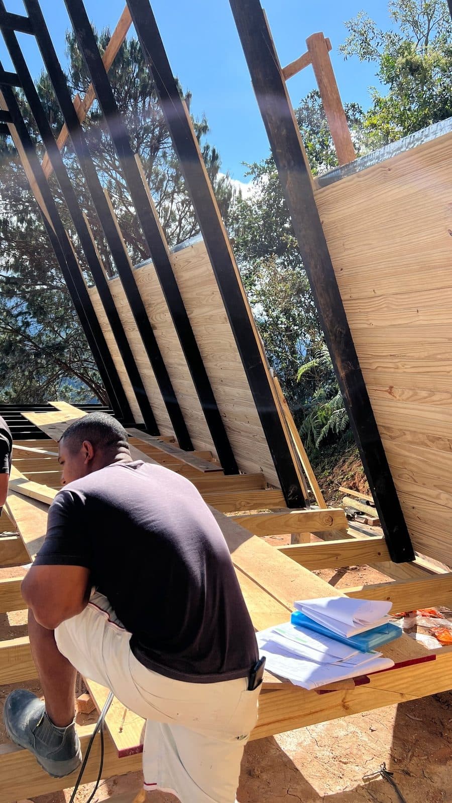 Equipe lendo o projeto dentro da estrutura A-frame em montagem