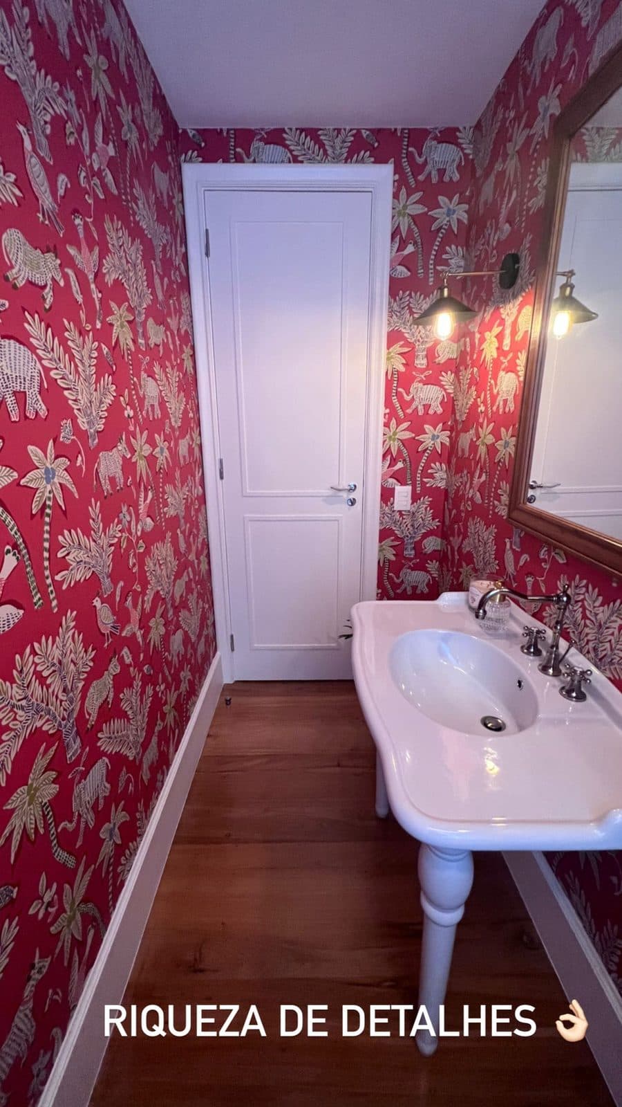 Lavabo com papel de parede vermelho, pia de coluna e assoalho