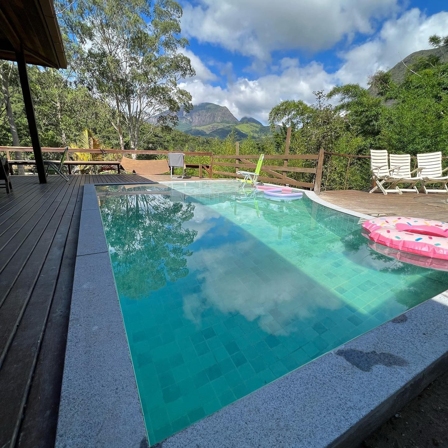 Piscina de borda infinita com água turquesa e montanhas ao fundo