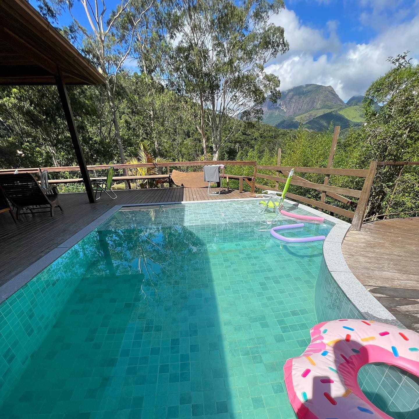 Piscina de pastilha turquesa com deck e vista das montanhas