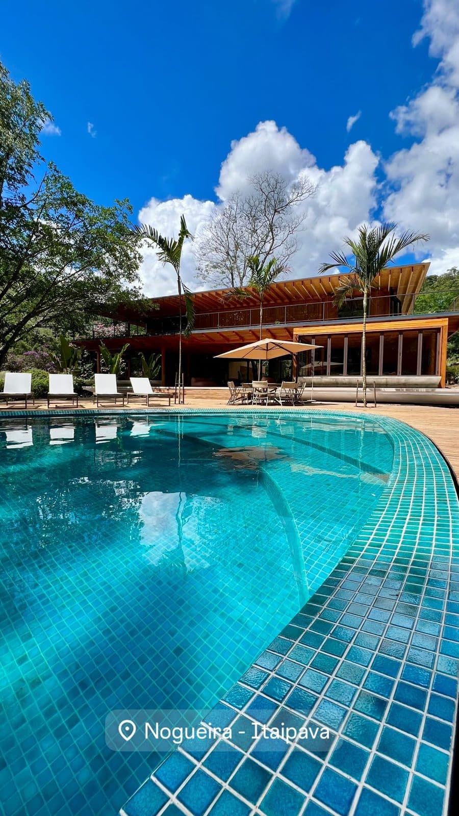 Casa de alto padrão com beirais de madeira, piscina e deck